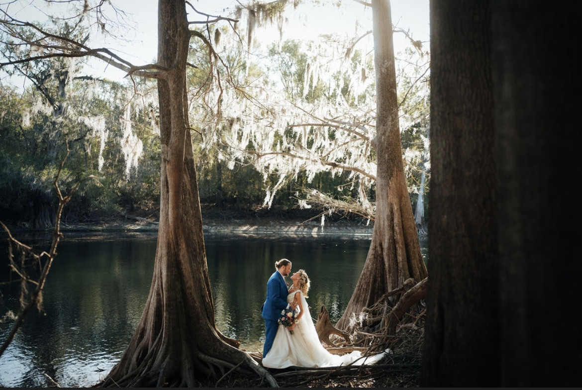 Madison and Sean beside the cypress trees on their wedding day